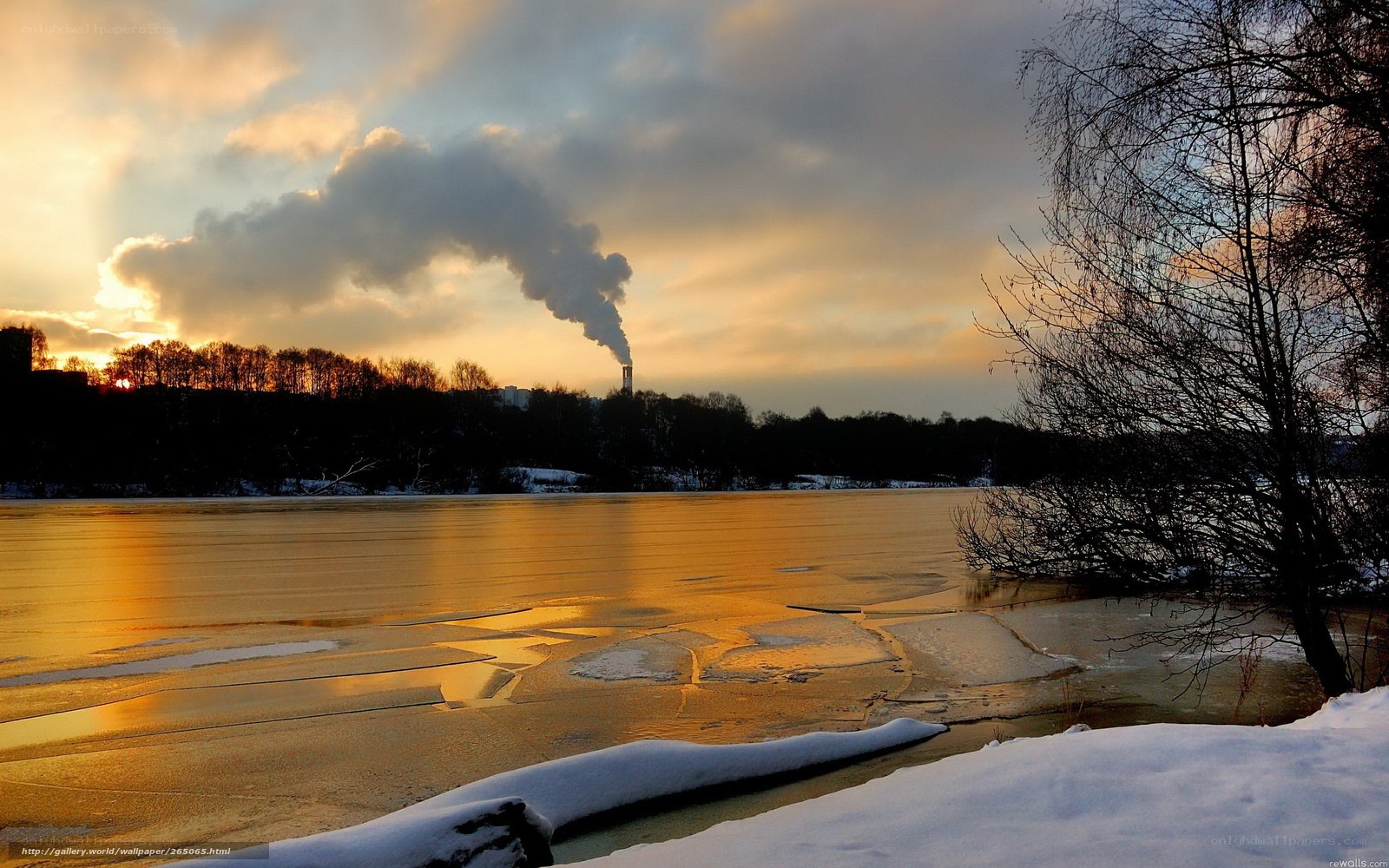 Frozen lake at sunset with smokestack