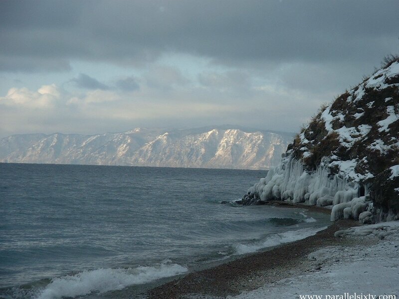 frozen lake shore with mountains