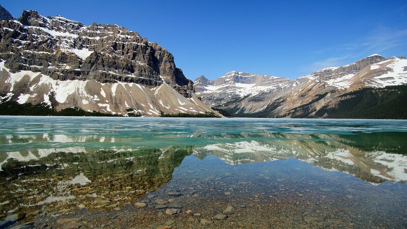 frozen lake with mountain reflection
