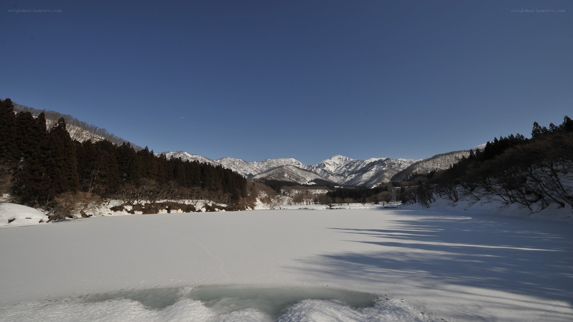 Frozen lake with snow-covered mountains
