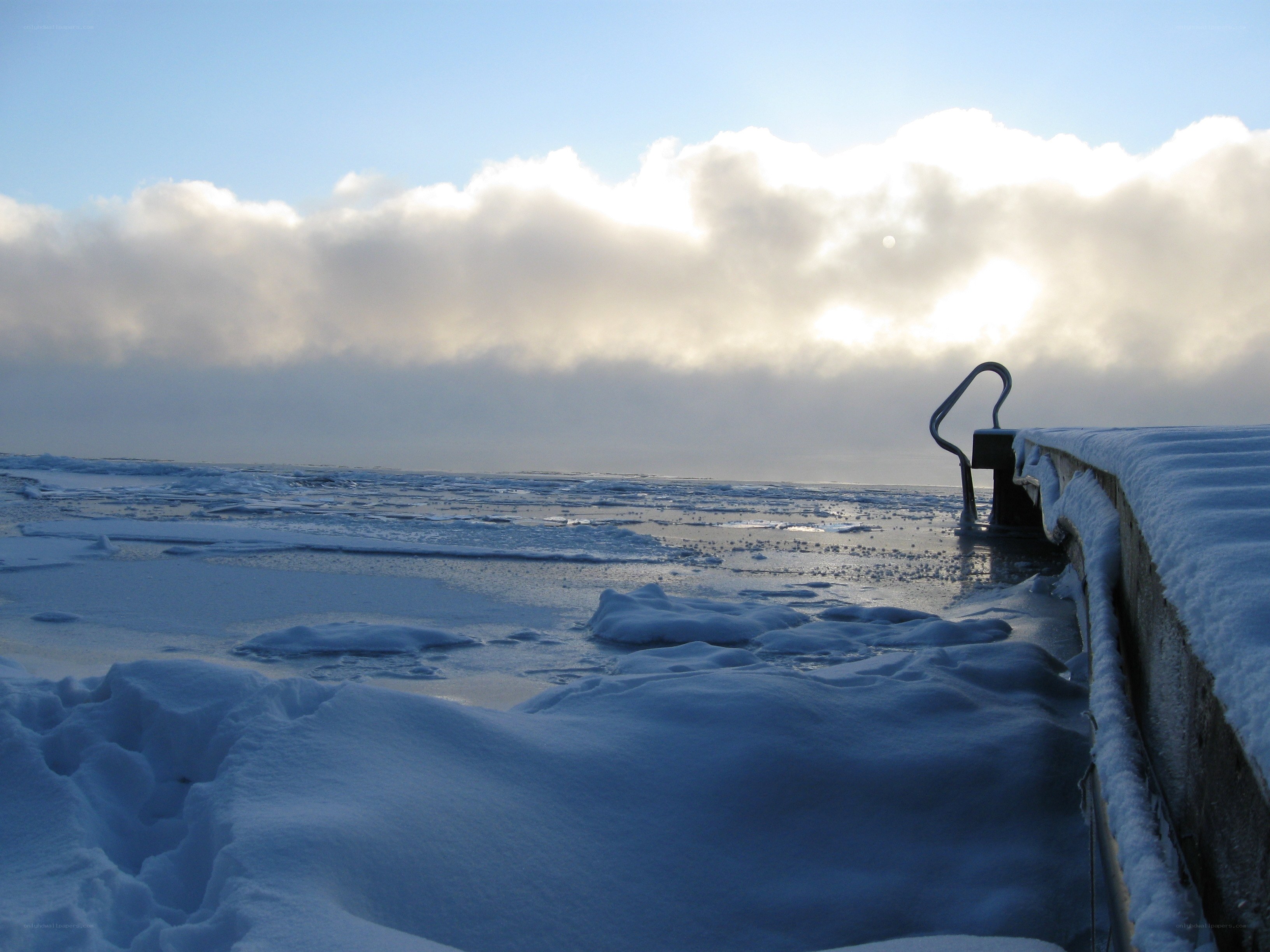 Frozen lake with snow-covered pier