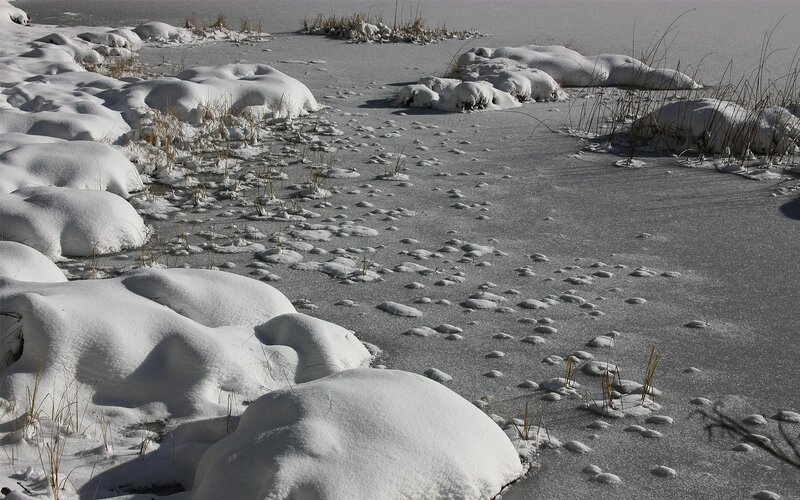 Frozen lake with snow mounds