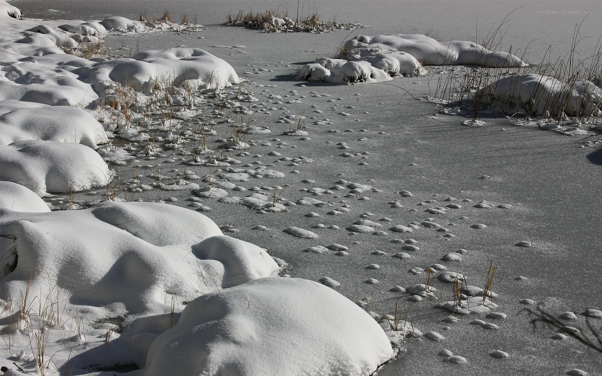 Frozen lake with snow mounds