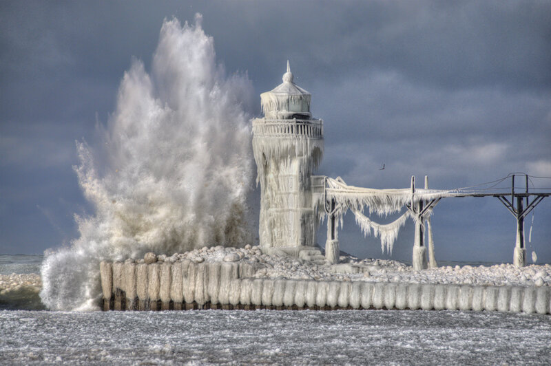 Frozen lighthouse with crashing waves