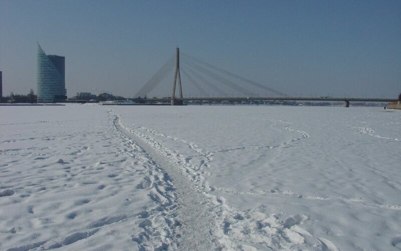Frozen river with bridge and skyscraper
