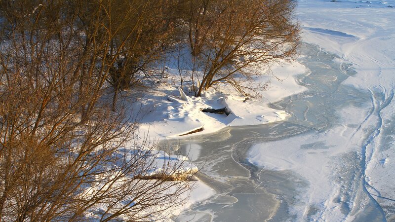 frozen river with snow and trees