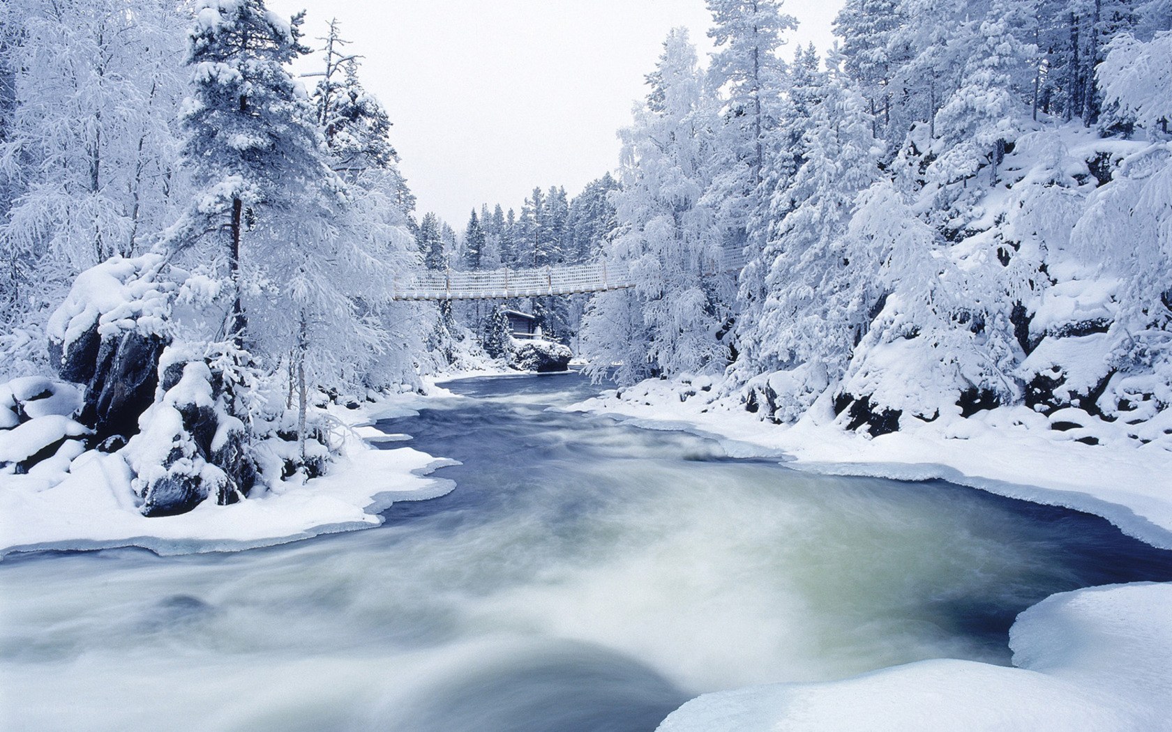 Frozen river with suspension bridge