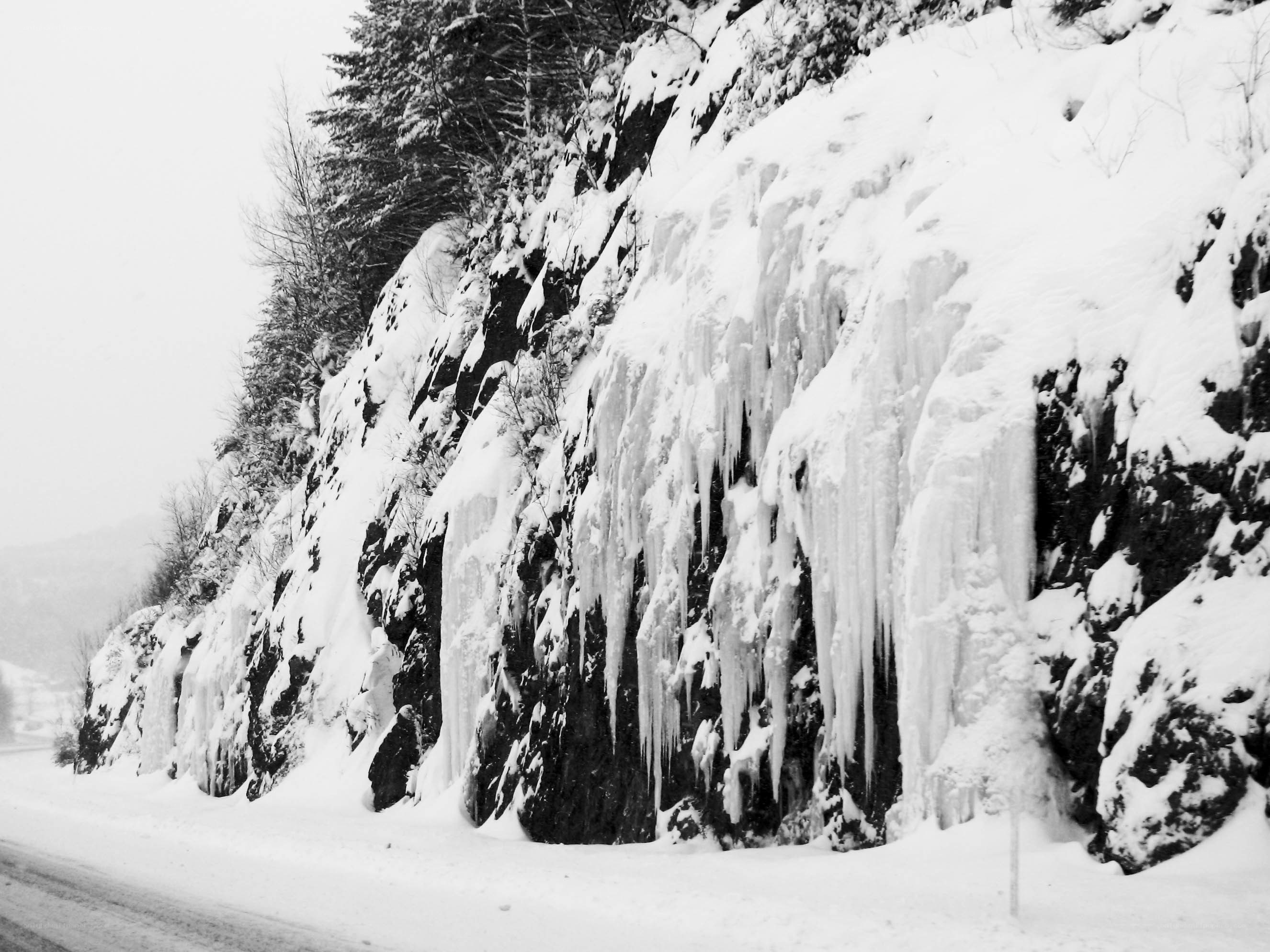 Frozen waterfall on a snowy cliff
