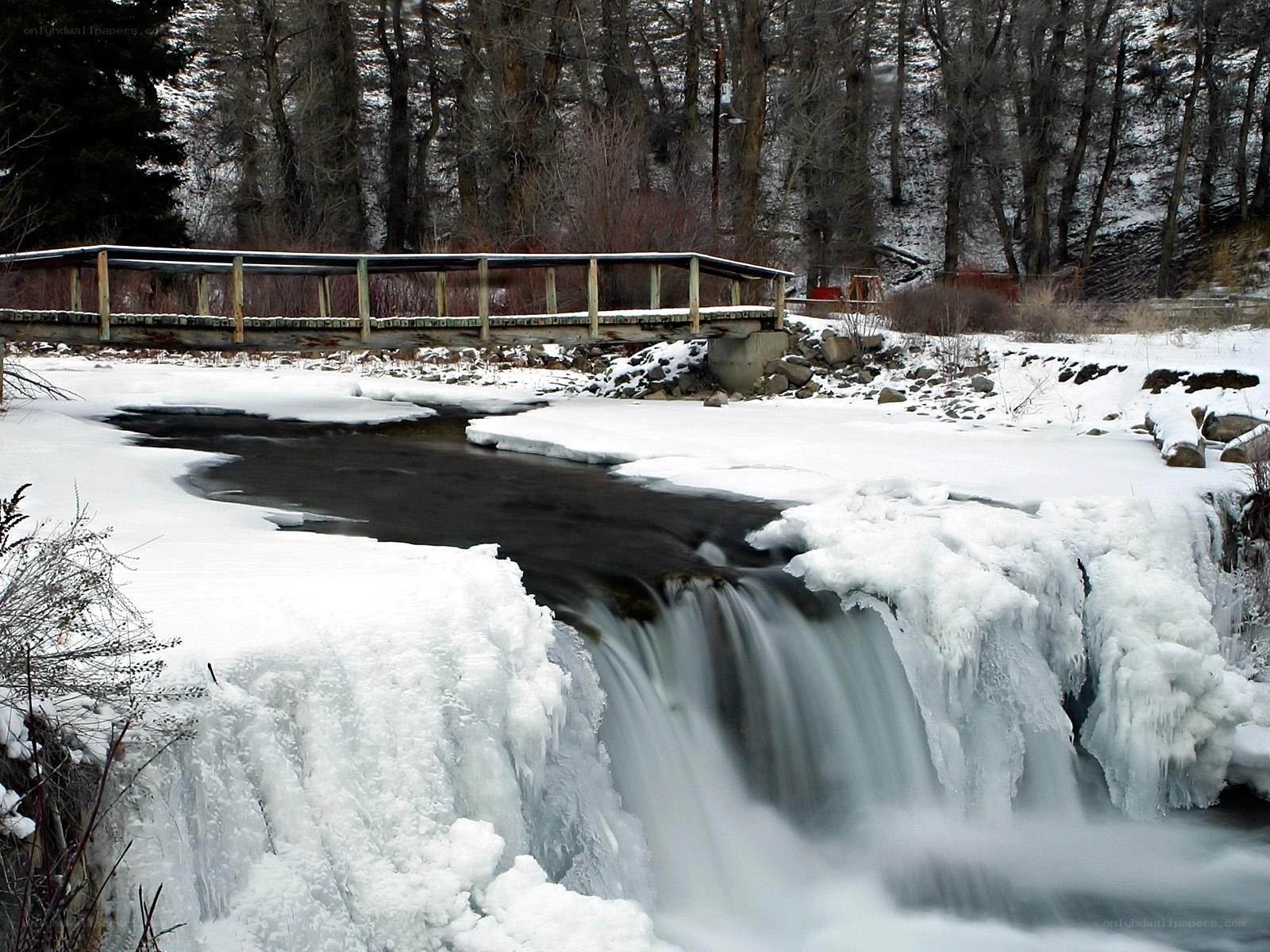 Frozen waterfall with wooden bridge