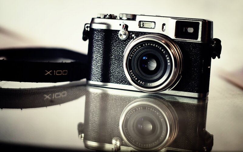 Fuji X100 camera on reflective surface