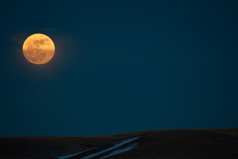 Full moon over a hill