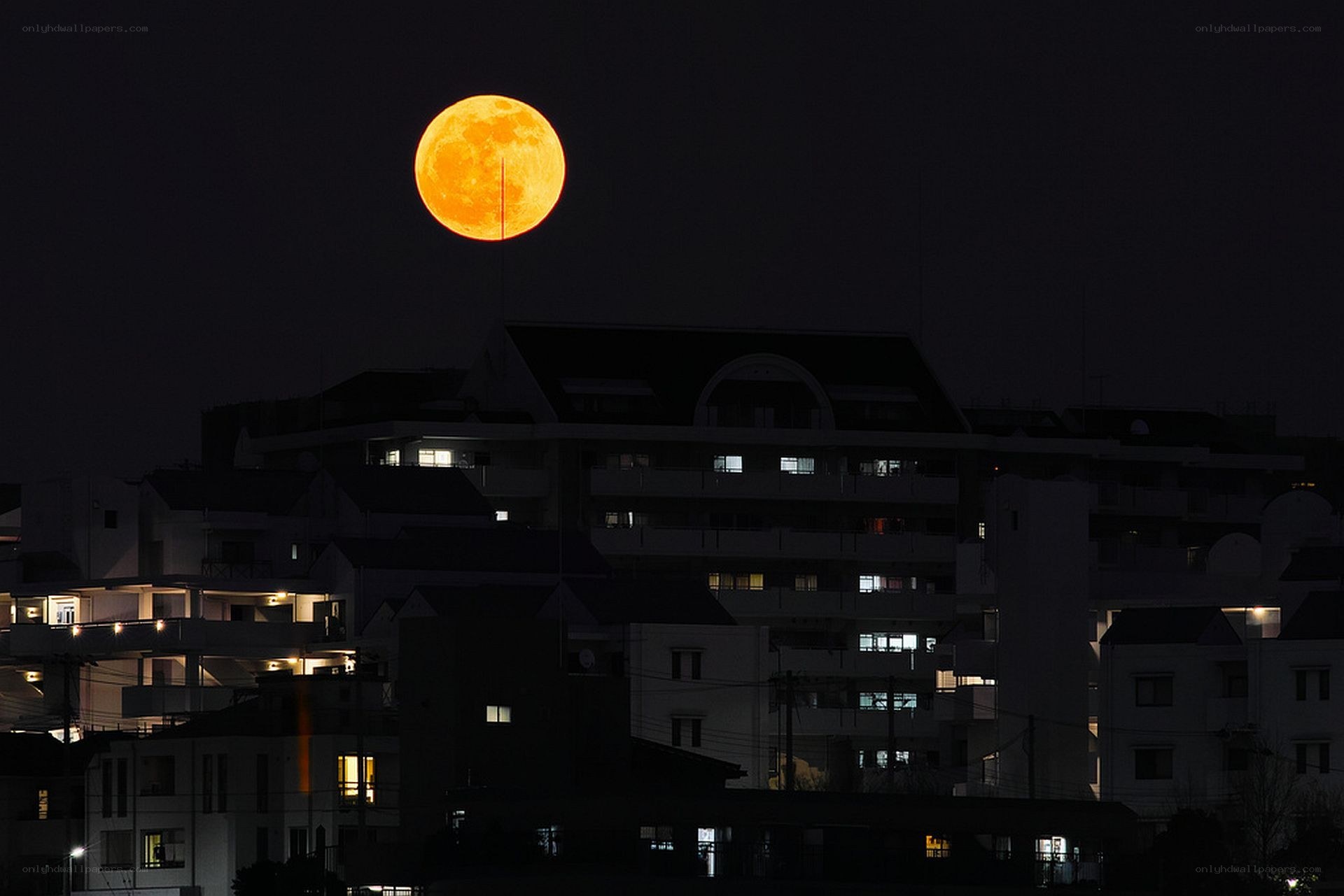 Full moon over city buildings
