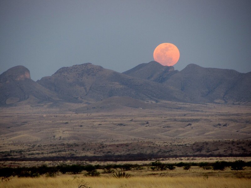 Full moon over desert mountains