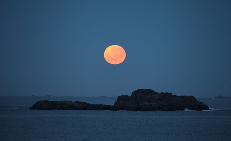 Full moon over rocky island