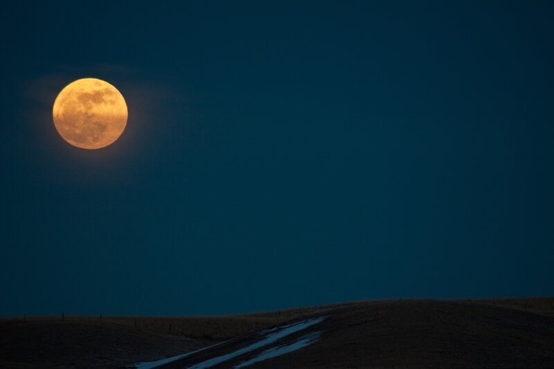 Full moon over rolling hills