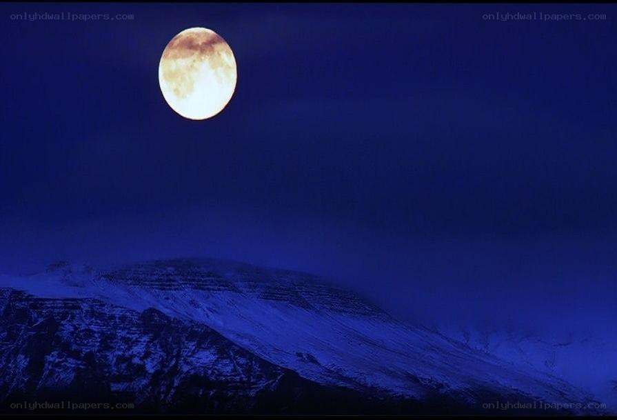 Full moon over snowy mountains