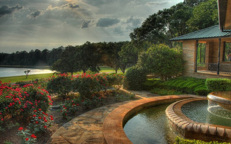 Garden fountain by lake at sunset