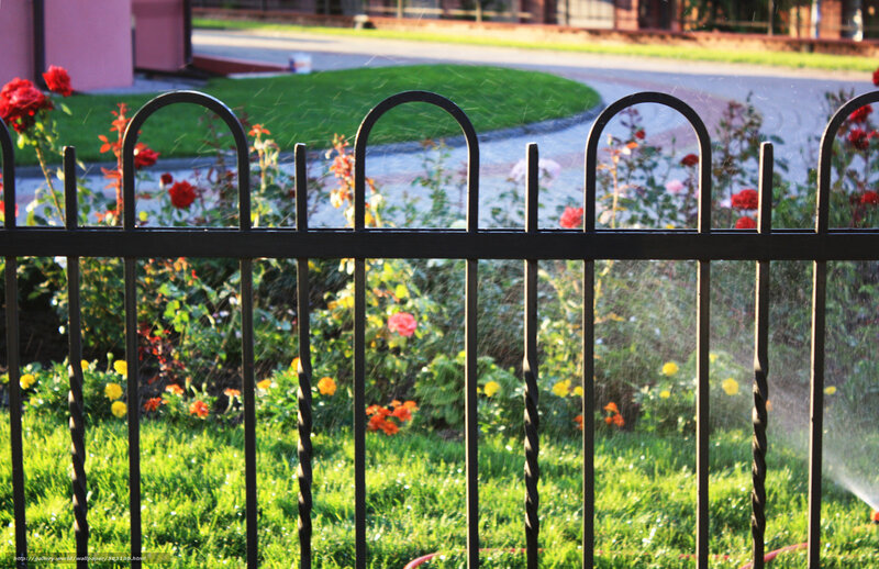 Garden sprinkler behind fence