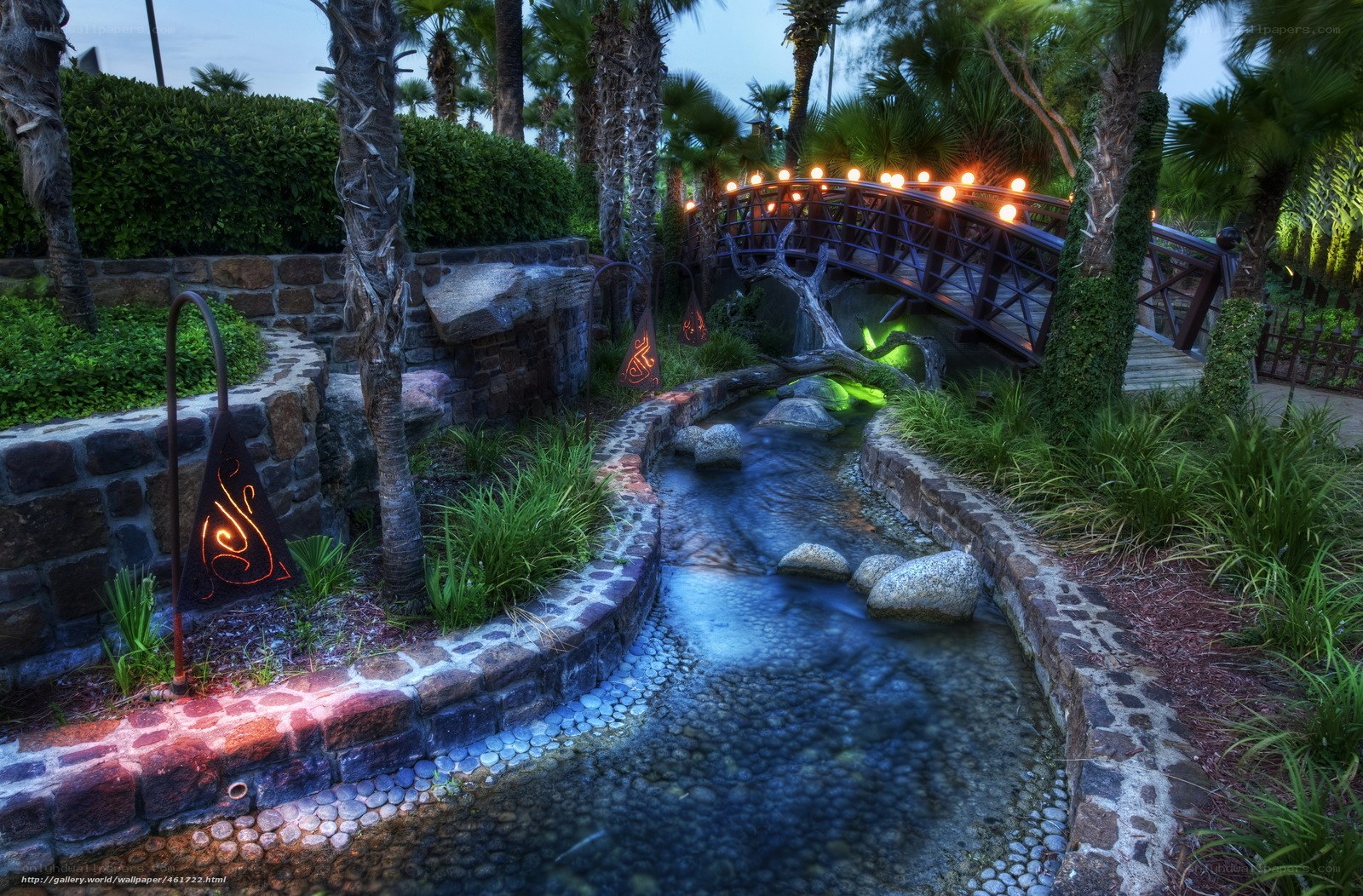 Garden stream with lit bridge