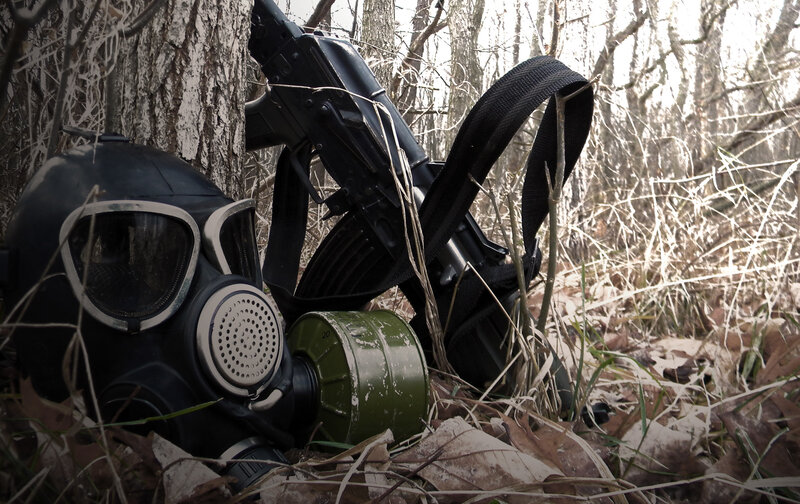 Gas mask and rifle in forest