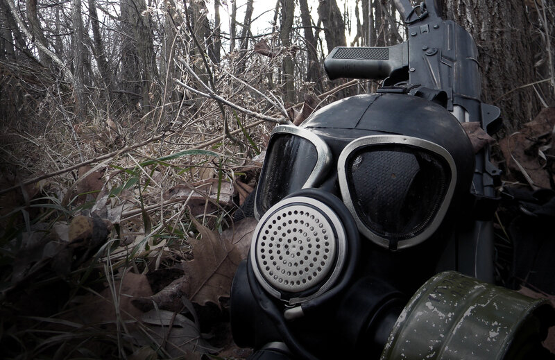 Gas mask and rifle in forest