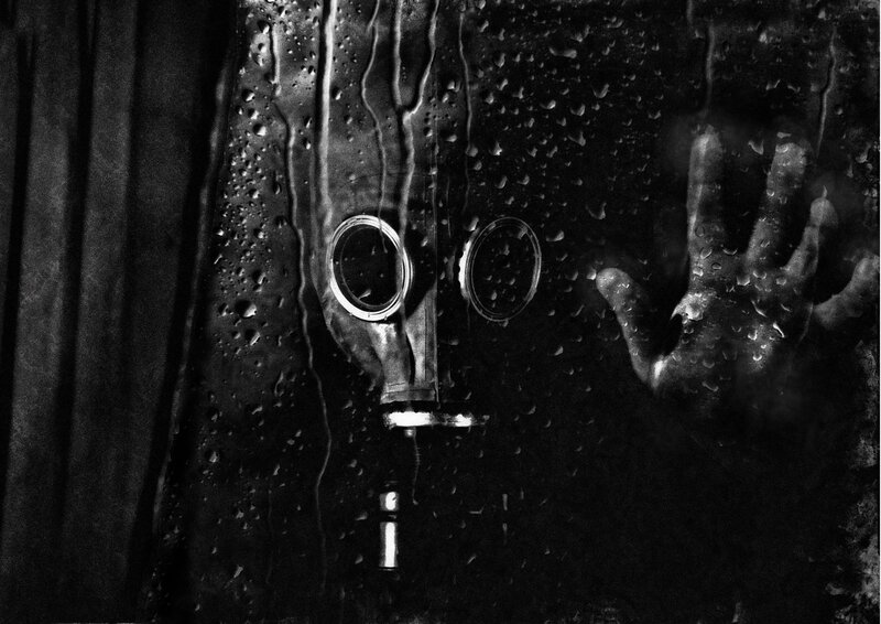 Gas mask behind wet glass