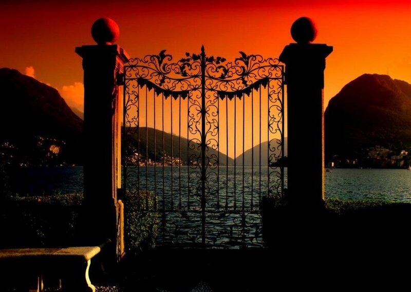 Gate overlooking a lake at sunset