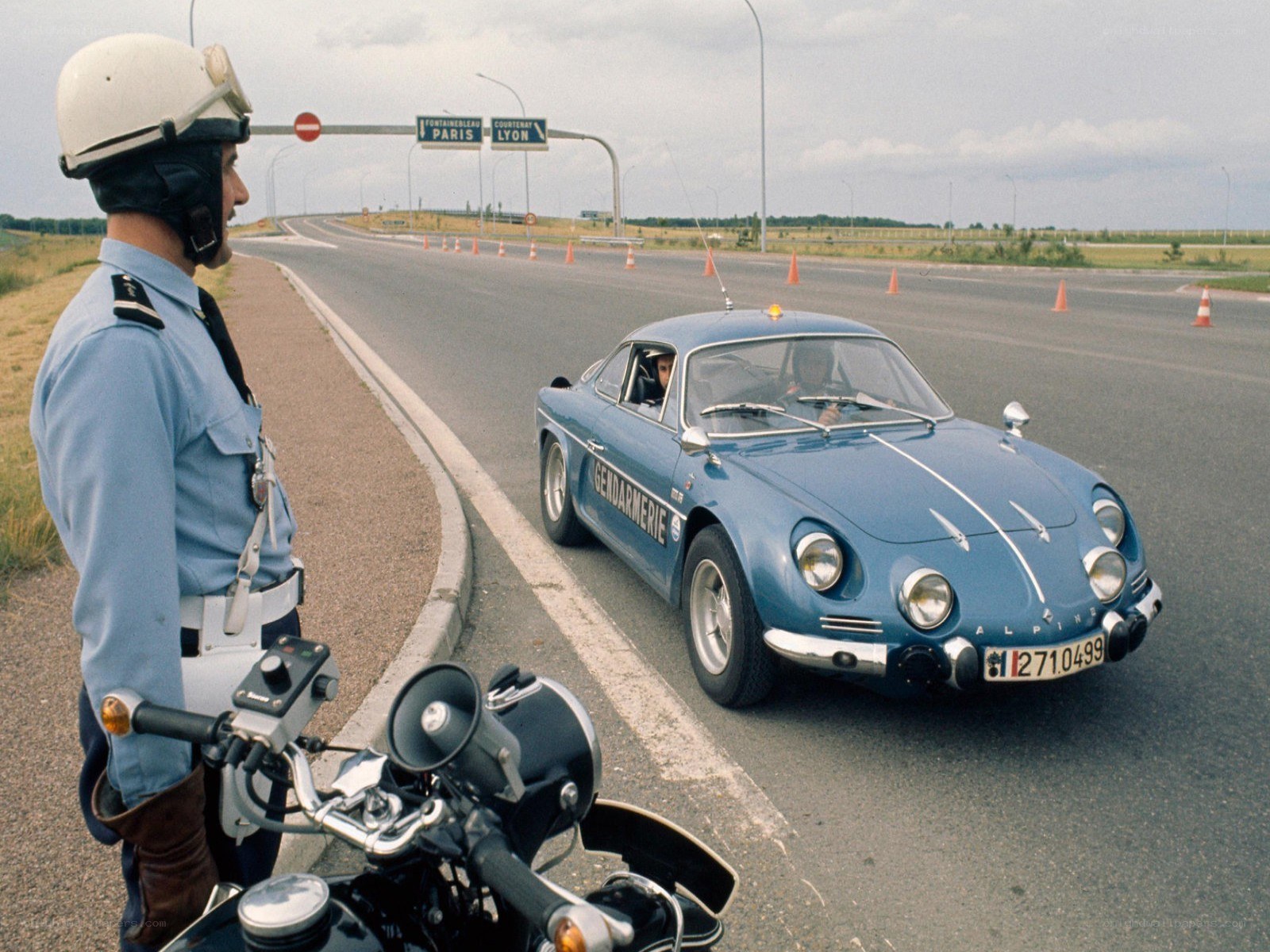 Gendarme on motorcycle with Alpine car
