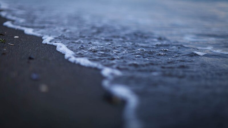 gentle waves on dark sand