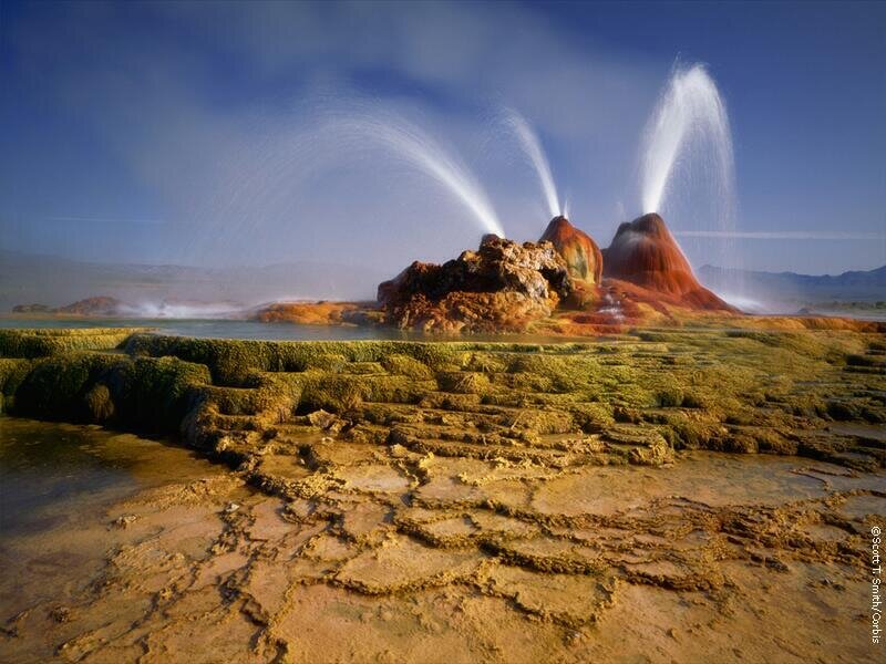 Geysers erupting in a colorful landscape