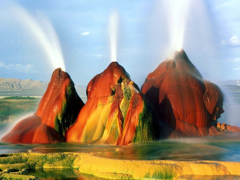 Geysers erupting in colorful landscape
