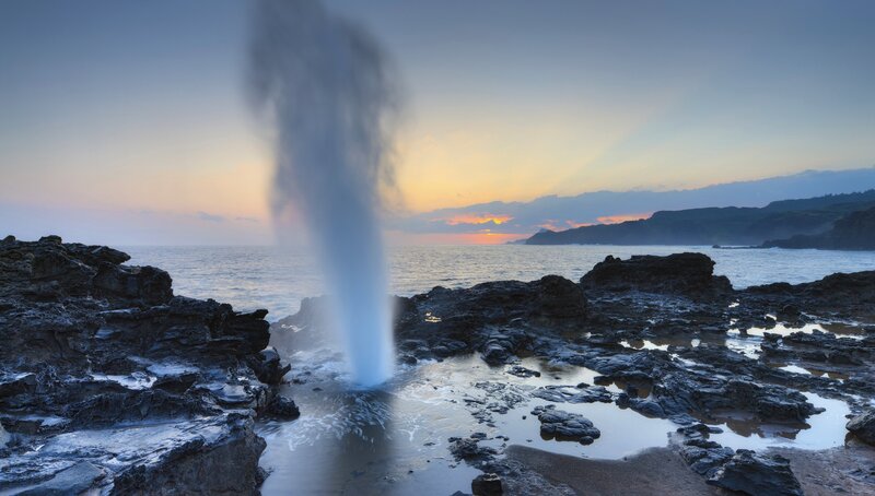 Geysir erupting at sunset