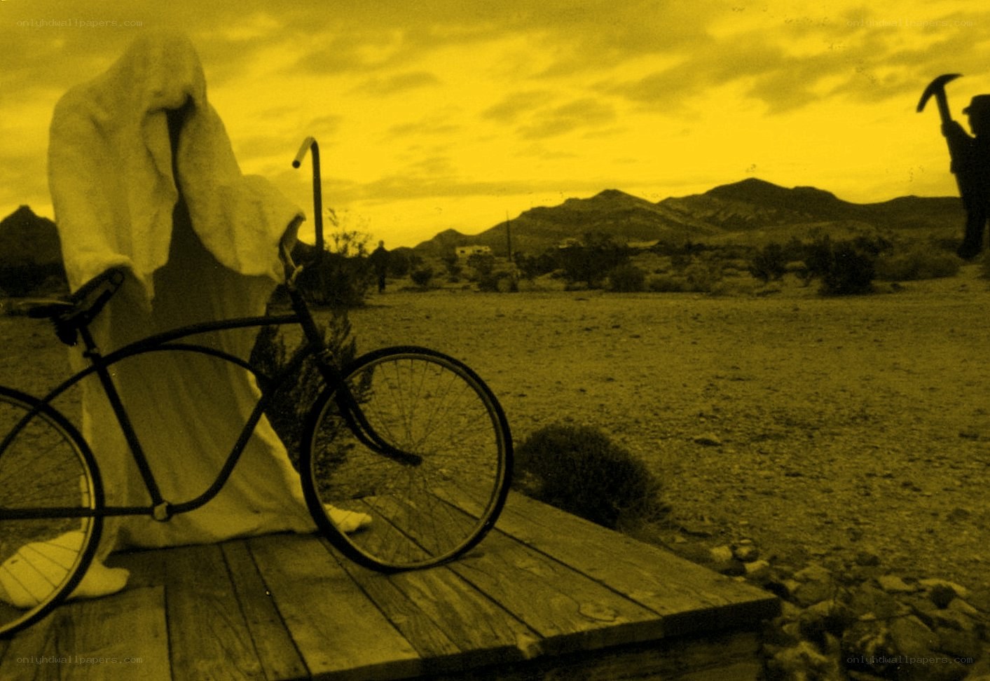 Ghostly figure with bicycle in desert