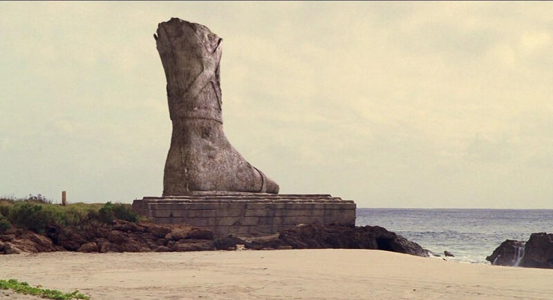 giant boot statue on beach