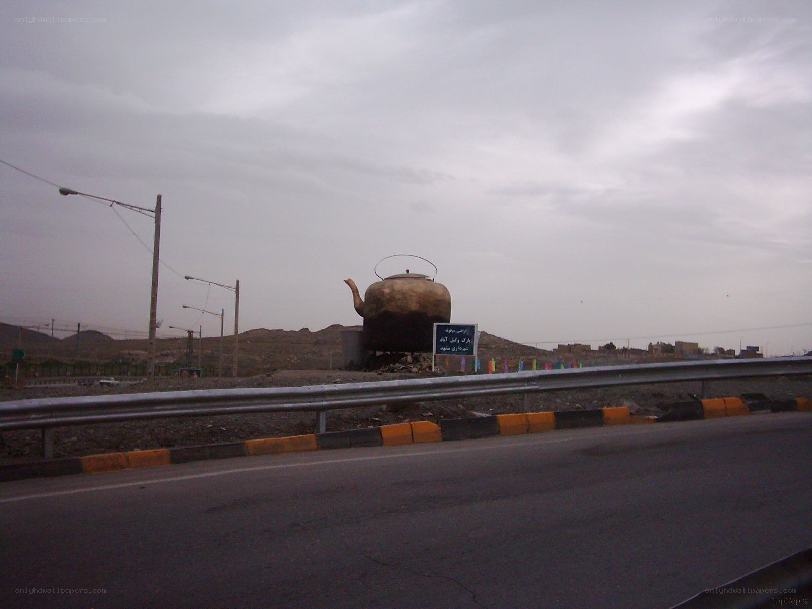 giant kettle sculpture on roadside