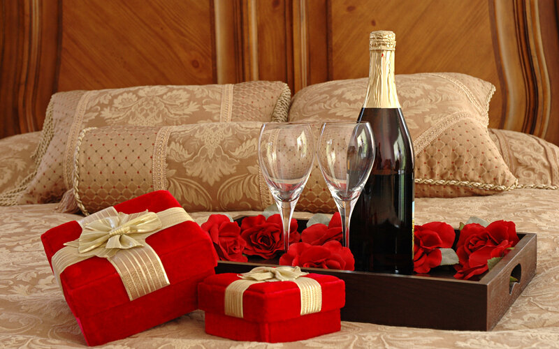 Gifts and Champagne on Bed — Red