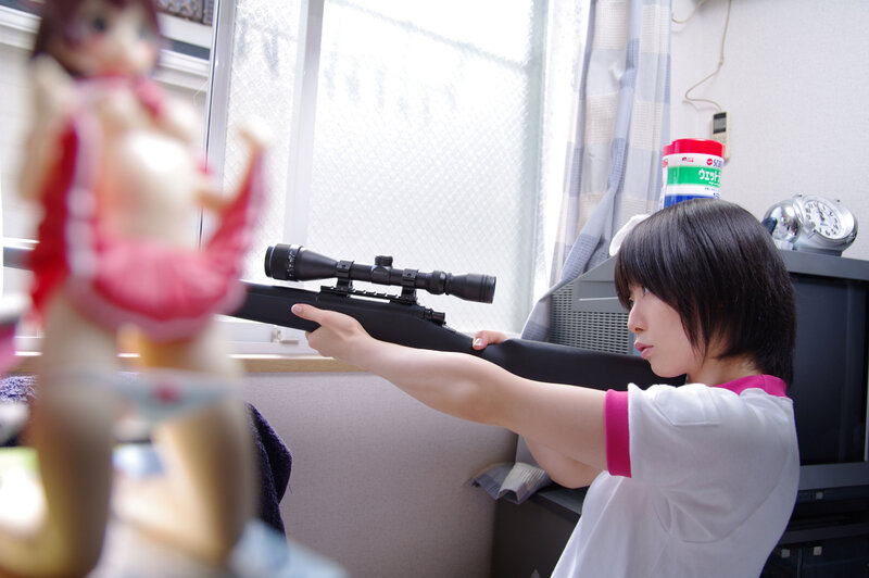 Girl aiming a rifle at a figurine