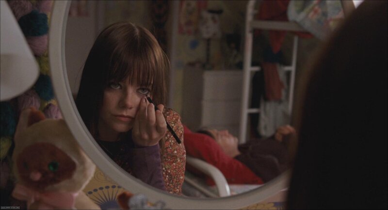 girl applying makeup in mirror