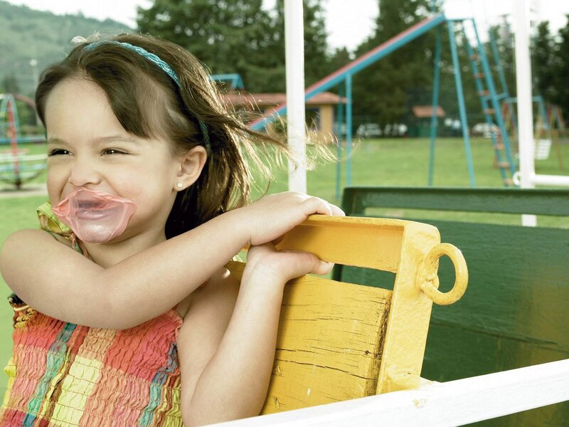 Girl blowing bubble gum at playground