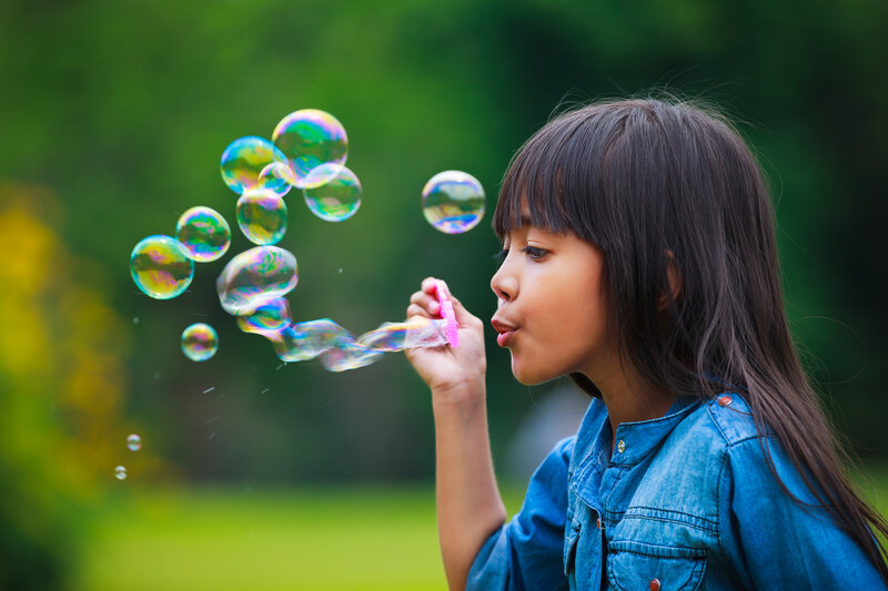 Girl Blowing Bubbles — Blue, Playful, Afternoon