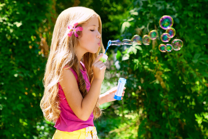 Girl Blowing Bubbles — Green, Playful, Afternoon
