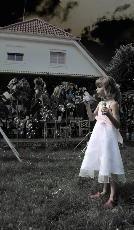 Girl blowing bubbles in garden