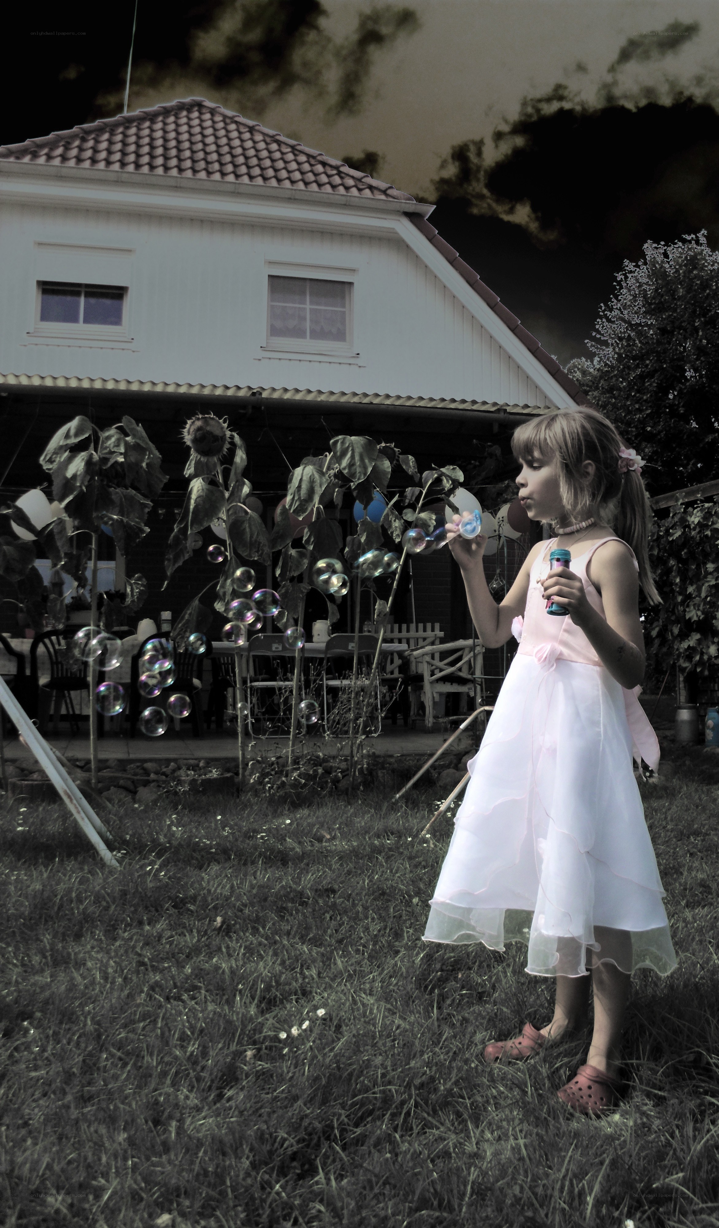 Girl blowing bubbles in garden