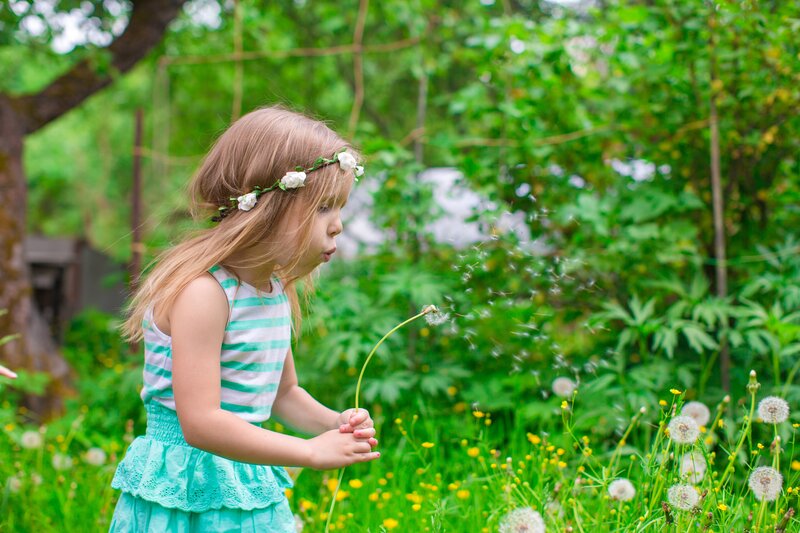 Girl Blowing Dandelion — Green, Peaceful