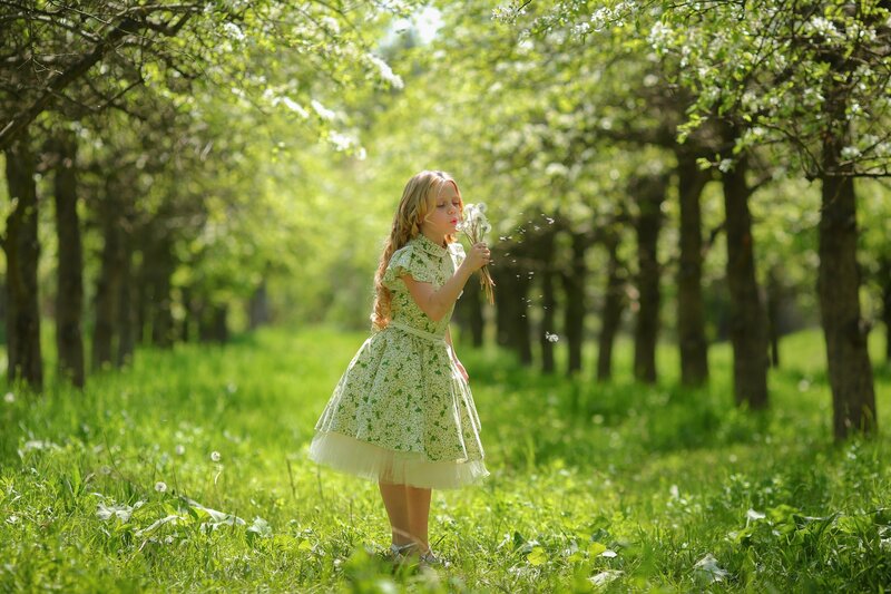 Girl Blowing Dandelion Seeds — Green, Serene, Spring