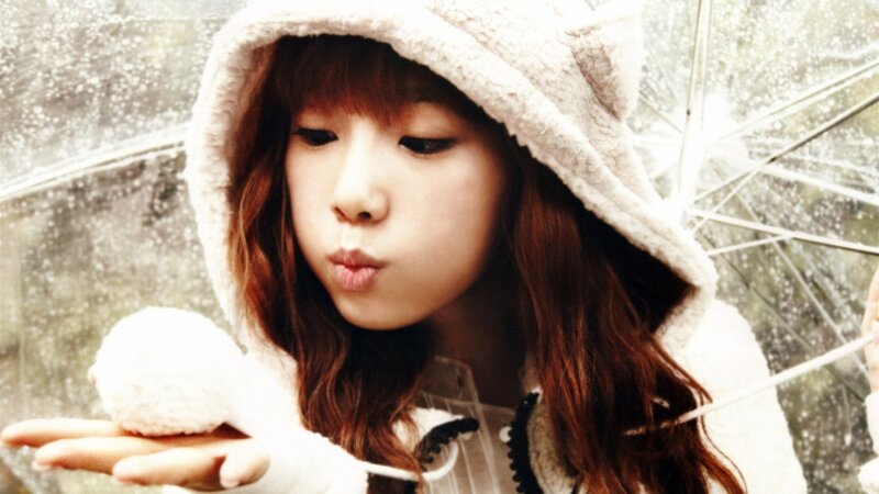 girl blowing snowball in rain