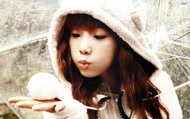girl blowing snowball in rain