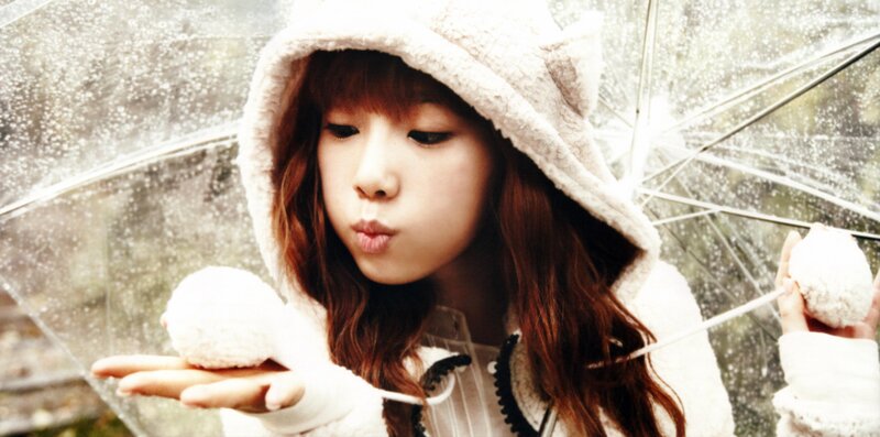 girl blowing snowballs in rain