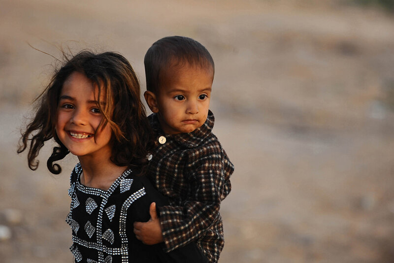 Girl Carrying a Toddler