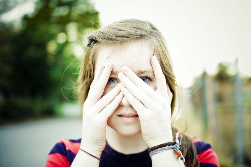girl covering eyes with hands